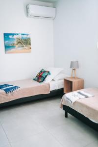a room with two beds and a lamp in it at Villas Riviera F4, Le Helleux, calme, lagon privé in Sainte-Anne