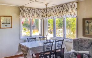uma sala de jantar com uma mesa e cadeiras e uma janela em Beautiful Home In Ljuster With Sauna, Wifi And 3 Bedrooms em Norra Ljustero