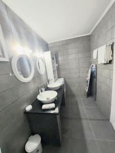 a bathroom with a sink and a toilet and a mirror at Villa Gardiki for2 in Halikounas