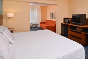a hotel room with a bed and a flat screen tv at Fairfield Inn St. Louis St. Charles in St. Charles