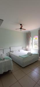 a bedroom with a bed and a ceiling fan at Pousada Florada na Serra in Serra do Cipo