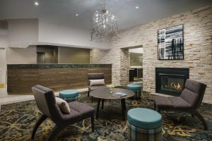 Residence Inn Gaithersburg Washingtonian Center في غايثرسبيرغ: لوبي فيه موقد وكراسي وطاولة