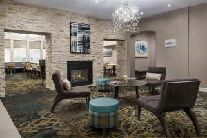 a lobby with a fireplace and chairs and a table at Residence Inn Gaithersburg Washingtonian Center in Gaithersburg