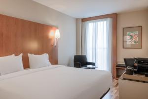 una habitación de hotel con una gran cama blanca y una ventana en AC Hotel Palencia by Marriott, en Palencia