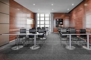 a conference room with tables and chairs and a window at AC Hotel Palencia by Marriott in Palencia