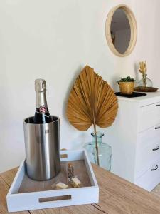 Una botella de champán en una nevera en una mesa en Maison gîte avec spa privé & piscine, en Mondragon