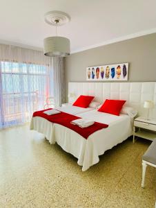 テルデにあるSalinetas Terraza Playaのベッドルーム(赤い枕の大きな白いベッド付)