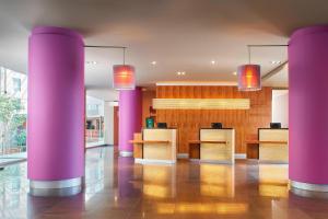 un vestíbulo con columnas rosas en un edificio en Courtyard by Marriott Mexico City Airport, en Ciudad de México