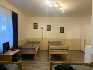 a room with two beds and a table and a lamp at Penzion U jezera in Konstantinovy Lázně
