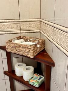 une corbeille assise au-dessus d'une étagère avec du papier toilette dans l'établissement Leśne PoBudki, à Białowieża