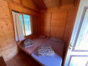 a small room with a bed in a wooden cabin at Social Camping JAL in Jal