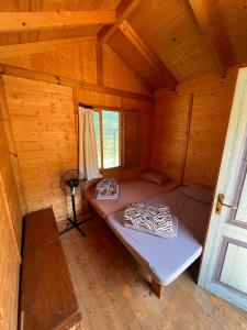 a room with a bed in a wooden cabin at Social Camping JAL in Jal