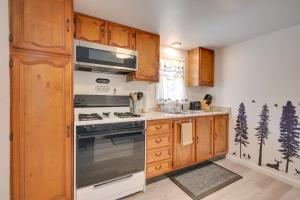 a kitchen with wooden cabinets and a stove top oven at Woodsy Family Retreat 11 Mi to Raystown Lake! 