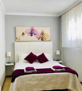 テルデにあるSalinetas Terraza Playaのベッドルーム(紫色の枕が付いた大きな白いベッド付)