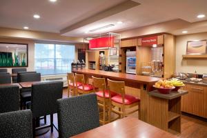 eine große Küche mit einer Bar mit Holztischen und Stühlen in der Unterkunft TownePlace Suites Milpitas Silicon Valley in Milpitas