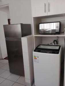 een kleine keuken met een magnetron en een koelkast bij Romina's Home in Lima