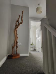 a hallway with a statue in the corner of a room at Shoreline Seaside Holiday Home Aberavon beach in Port Talbot