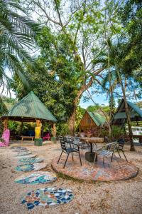 uma área de piquenique com mesa, cadeiras e árvores em Pura Vida Mini Hostel Santa Teresa em Santa Teresa