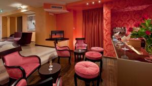 un salone con sedie rosa e un barbiere di c-hotels Fiume a Roma