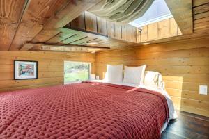 una camera da letto con un grande letto rosso in una camera di legno di Abingdon Vacation Rental Tiny Home on 10-Acre Farm ad Abingdon