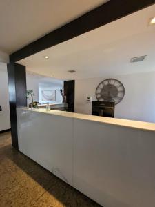 a lobby with a counter with a clock on the wall at Hotel Alvorada Taguatinga - Antigo Hotel Atlantico in Taguatinga