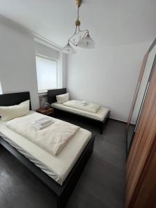 Zimmer mit 2 Betten und einem Kronleuchter in der Unterkunft Nik Apartment in Oberhausen