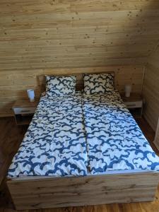 een bed met een blauw en wit dekbed en 2 kussens bij Lucky house Borsk in Borsk