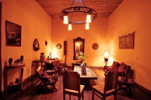 ein Wohnzimmer mit einem Tisch, Stühlen und einem Kronleuchter in der Unterkunft Hotel Boutique La Merced in Pasto
