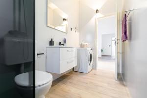 a bathroom with a toilet and a washer and dryer at Penthouse Nensi in Baška Voda