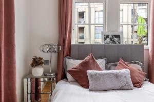 1 dormitorio con cama con almohadas y ventana en Westminster Big Ben Apartment, en Londres