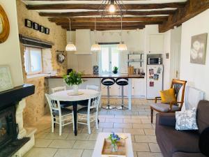 a living room with a table and a kitchen at Gîte du Rossignol entre lac et forêt in Mervent