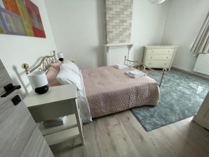 a small bedroom with a bed and a night stand at Agréable duplex proche de toutes commodités in Ans