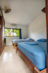 1 dormitorio con 2 camas y ventana en Pura Vida Mini Hostel Santa Teresa, en Santa Teresa Beach