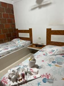 Hostal El Paraiso في Jamundí: غرفة بسريرين عليها مناشف