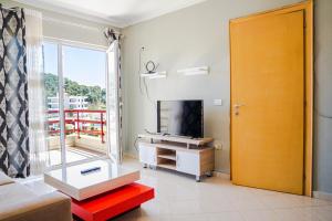 ein Wohnzimmer mit einem Sofa, einem TV und einem Fenster in der Unterkunft Bianca Apartament in Golem