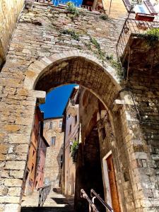 einen Torbogen in einem alten Steingebäude mit einer Straße in der Unterkunft Perugia Mini Flat in Perugia