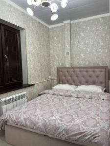una camera con letto e piumone rosa di Miracle Apartment a Samarkand