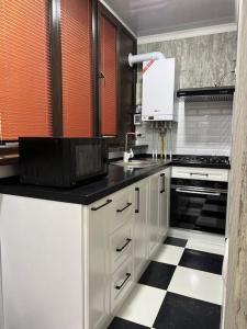 una cucina con pavimento a scacchi in bianco e nero di Miracle Apartment a Samarkand