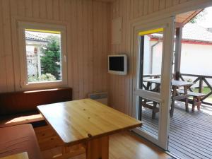 a room with a table and a tv on a deck at Ferienhaus in Dziwnw mit Terrasse, Garten und Grill in Dziwnów