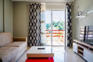 ein Wohnzimmer mit Sofa und Blick auf einen Balkon in der Unterkunft Bianca Apartament in Golem