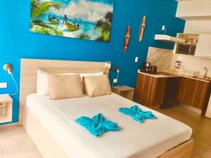 a bedroom with a white bed with blue bows on it at Estudio exclusivo in The City - TOP amenidades! in Playa del Carmen