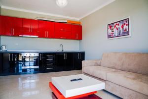 ein Wohnzimmer mit roten Schränken und einem Sofa in der Unterkunft Bianca Apartament in Golem