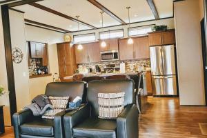 a kitchen with leather chairs and a kitchen with a refrigerator at Water Front very spacious Cottage on Rice Lake with 5 Star Golf Resort in Keene