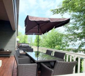 a table and chairs with an umbrella on a deck at Water Front very spacious Cottage on Rice Lake with 5 Star Golf Resort in Keene