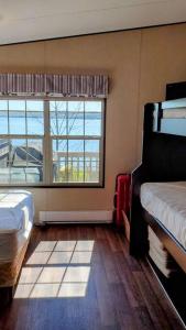a room with two beds and a large window at Water Front very spacious Cottage on Rice Lake with 5 Star Golf Resort in Keene