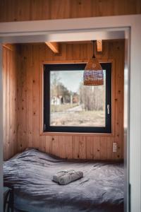 a bedroom with a window in a wooden cabin at Las Angels in Morąg