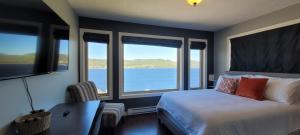 Schlafzimmer mit einem Bett und Blick auf das Wasser in der Unterkunft Coastal Lookout Suites in Corner Brook