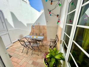 balcón con mesa y sillas en el patio en Algarve HOSTEL, en Faro