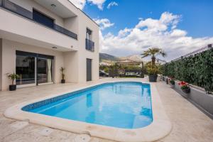 a swimming pool in the backyard of a house at Sunluxvilla ,Heated Pool, IR Sauna in Kaštela