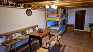 a room with bunk beds and a table and a desk at La sălaşul fermecat în Cheile Carasului in Iabalcea